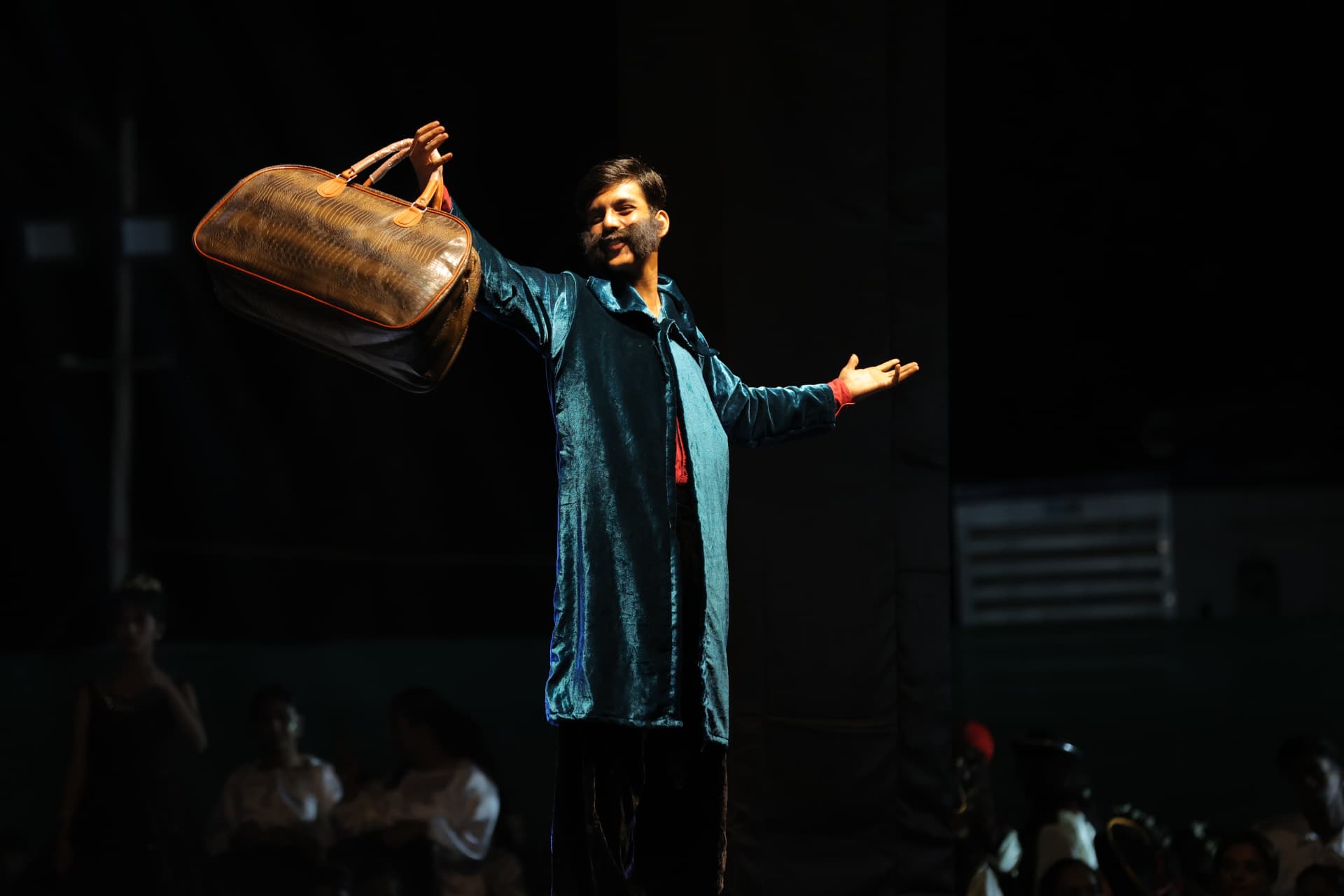 Actor with a travelling bag in a single spotlight
